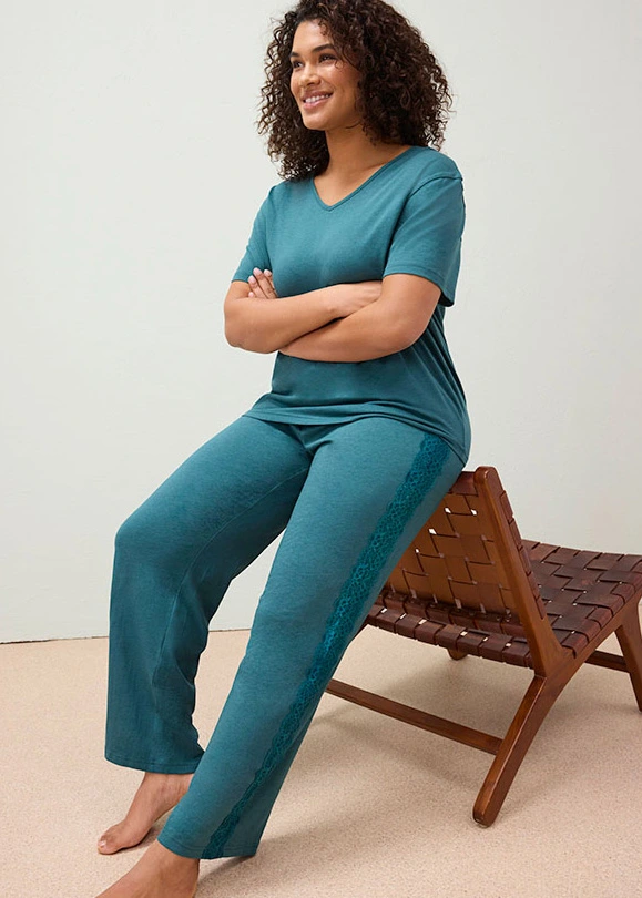 Vrouwelijke pyjama met diepe V-hals, korte mouwen en bloemenkant op het rugpand en de pijpen.