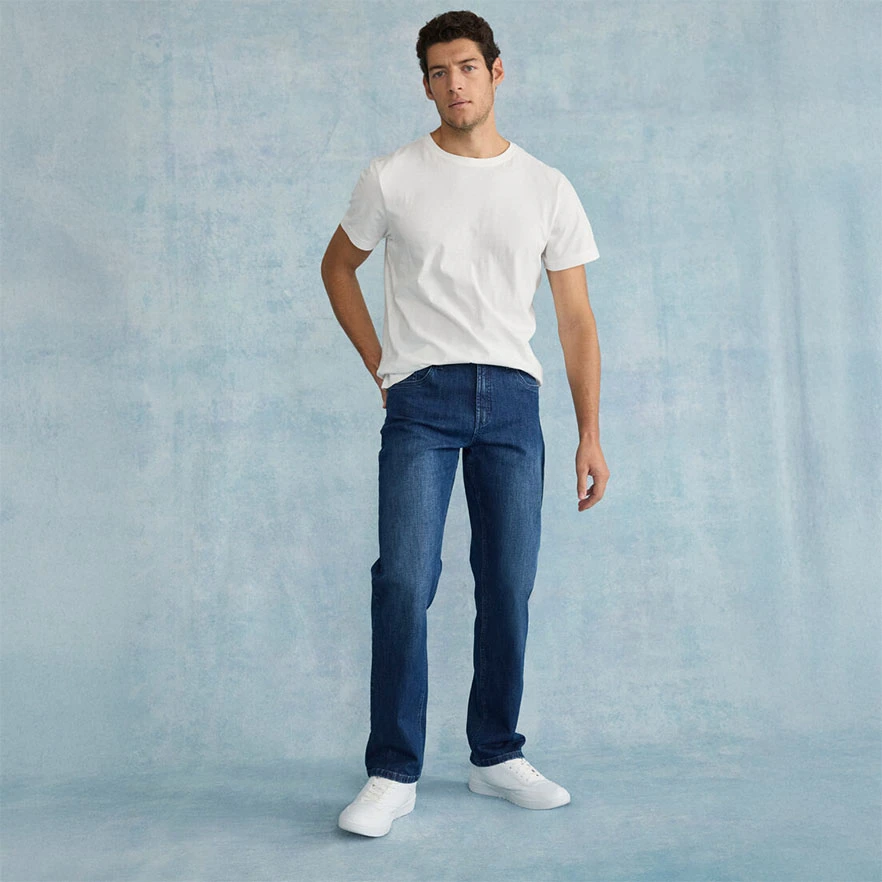 Wit T-shirt, blauwe relaxed fit jeans en witte sneakers.
