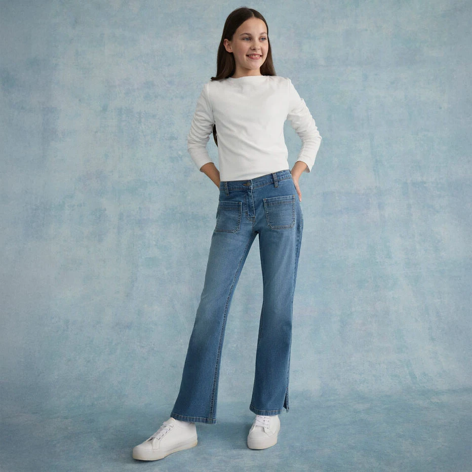 Eenvoudig wit shirt met lange mouwen, gecombineerd met een casual jeans en witte sneakers.