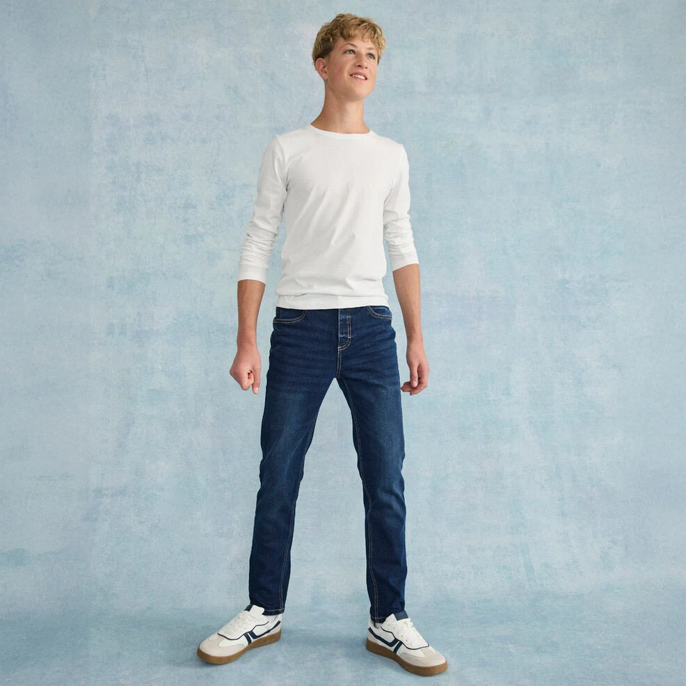Casual look met een wit shirt met lange mouwen, een klassieke jeans en witte sneakers.