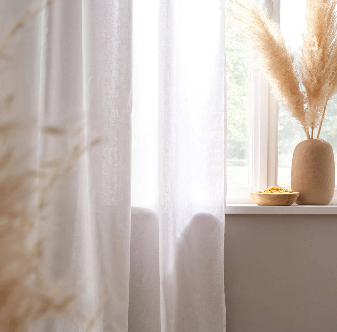 Lichte, witte gordijnen vallen elegant op de vloer.