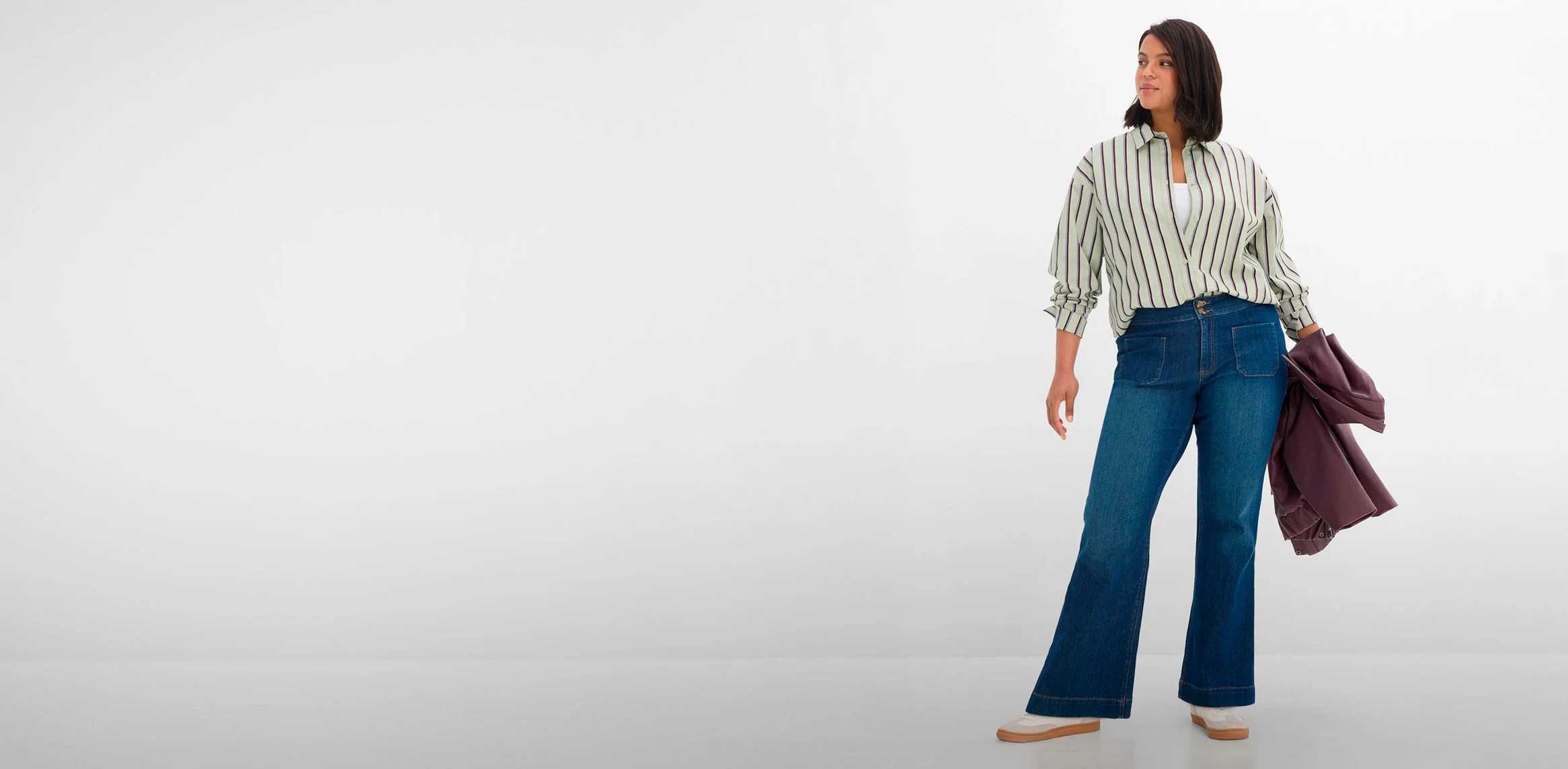 Vrijetijdsoutfit: gestreept overhemd, blauwe uitlopende jeans en modern jasje.