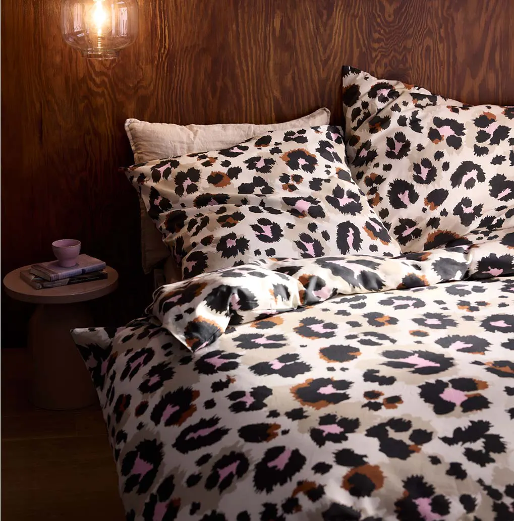 Beddengoed met panterprint in zwartbruine vlekken en roze accenten.
