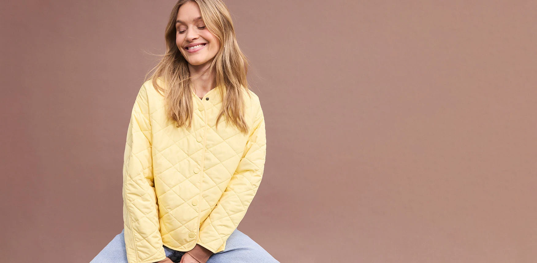 Gele oversized gewatteerde jas gecombineerd met blauwe broek.