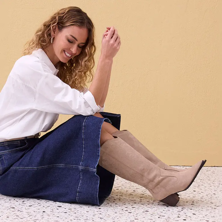 Witte blouse, wijde spijkerrok, beige laarzen.