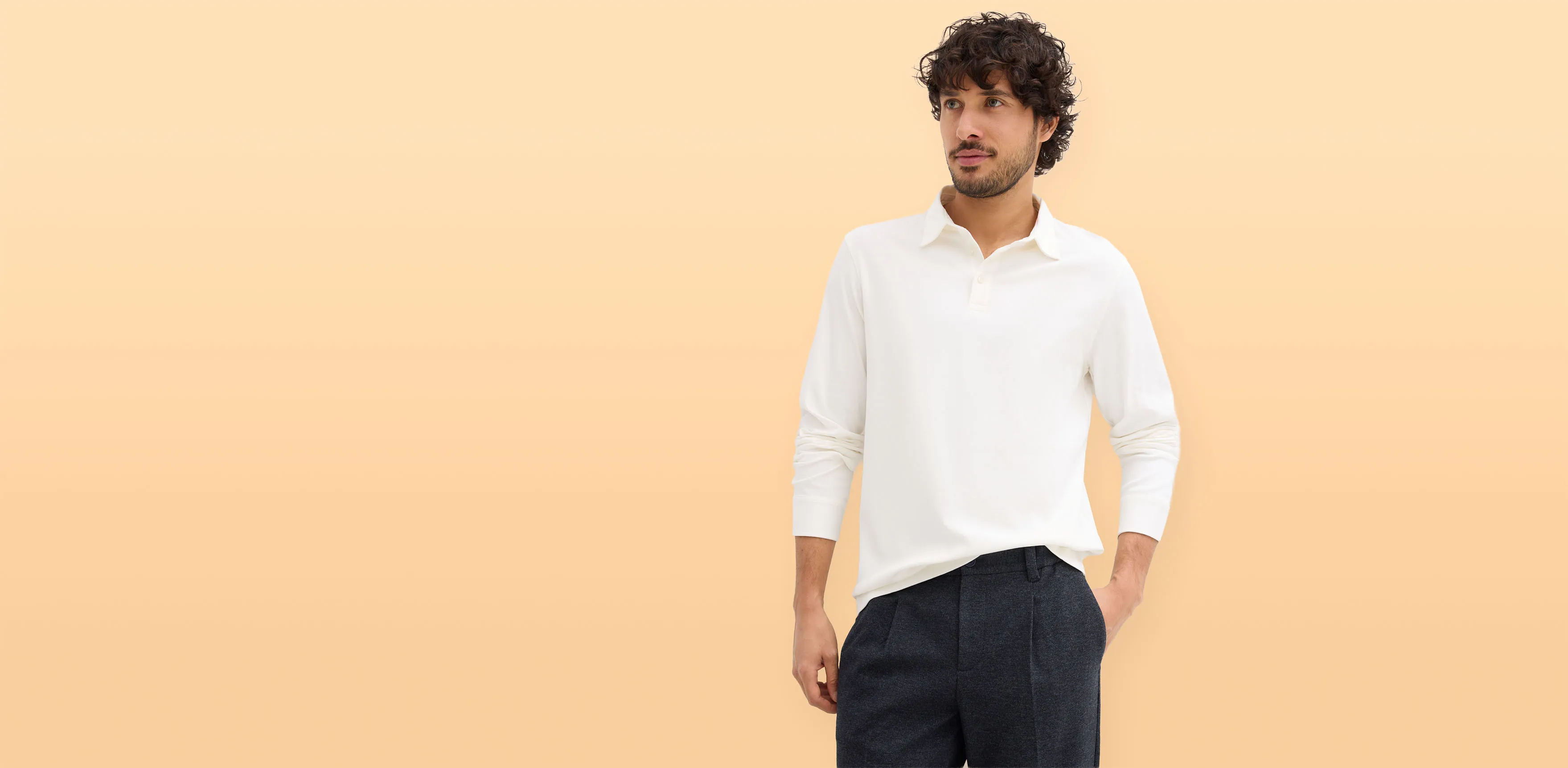 Minimalistisch wit poloshirt gecombineerd met donkere broek.