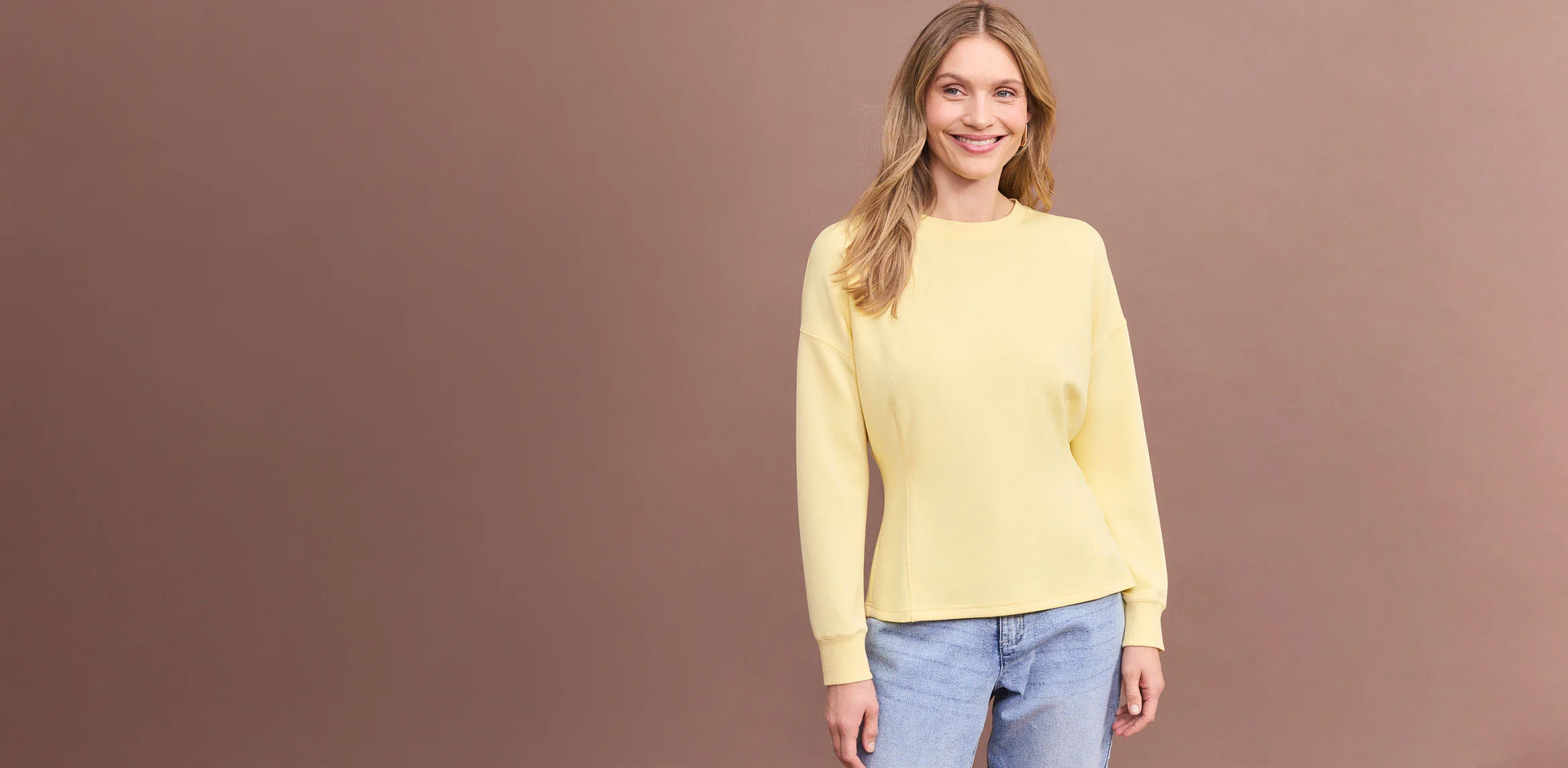 Bruine top met lange mouwen en comfortabele blauwe jeans.