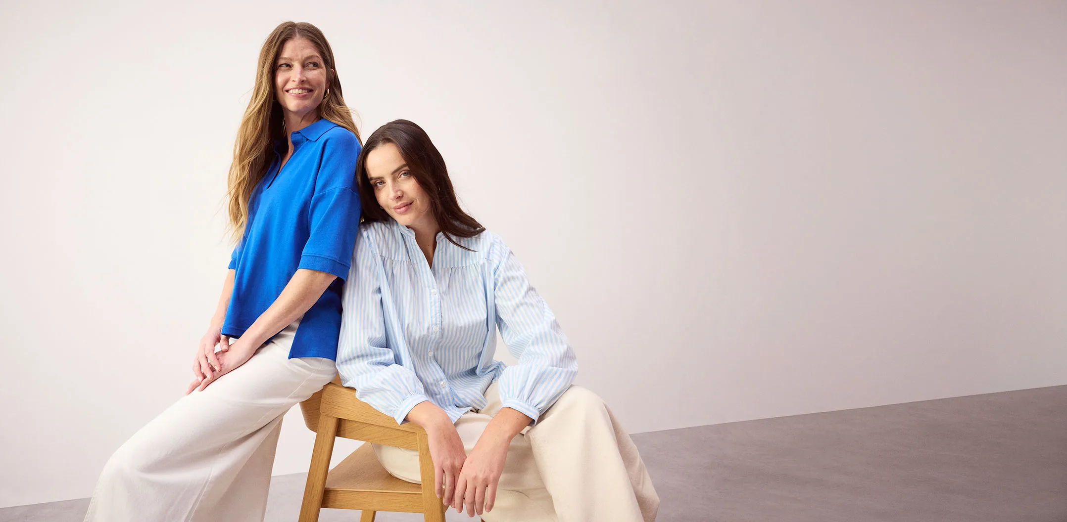 Blauw poloshirt en gestreepte blouse gecombineerd met lichte broek voor een casual look.