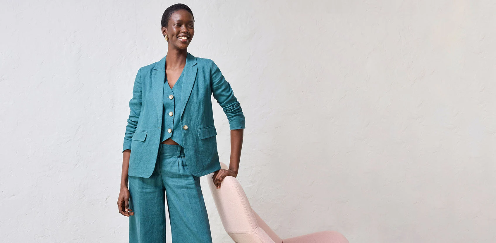 Turkoois broekpak met wijde broek, gilet en blazer.