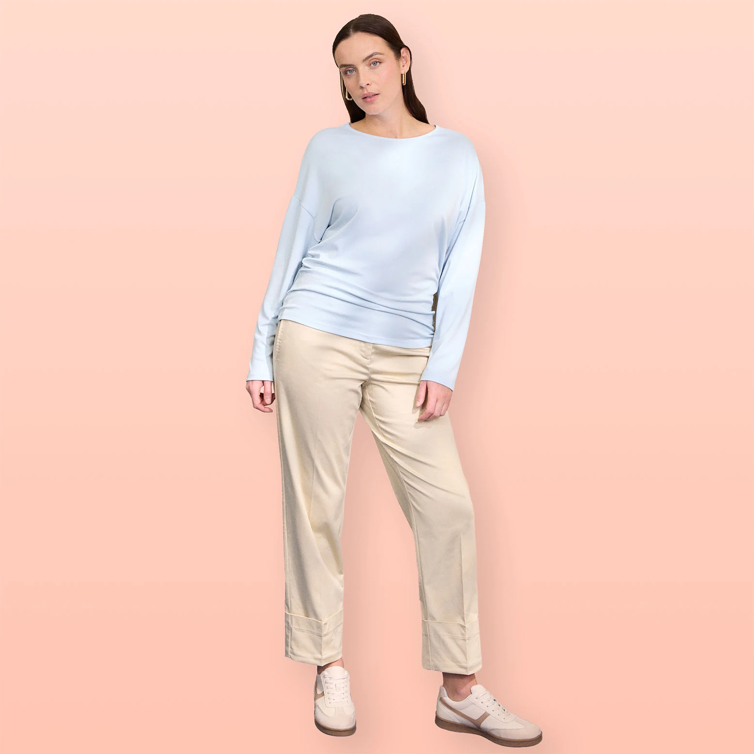 Lichtblauwe trui en beige broek.