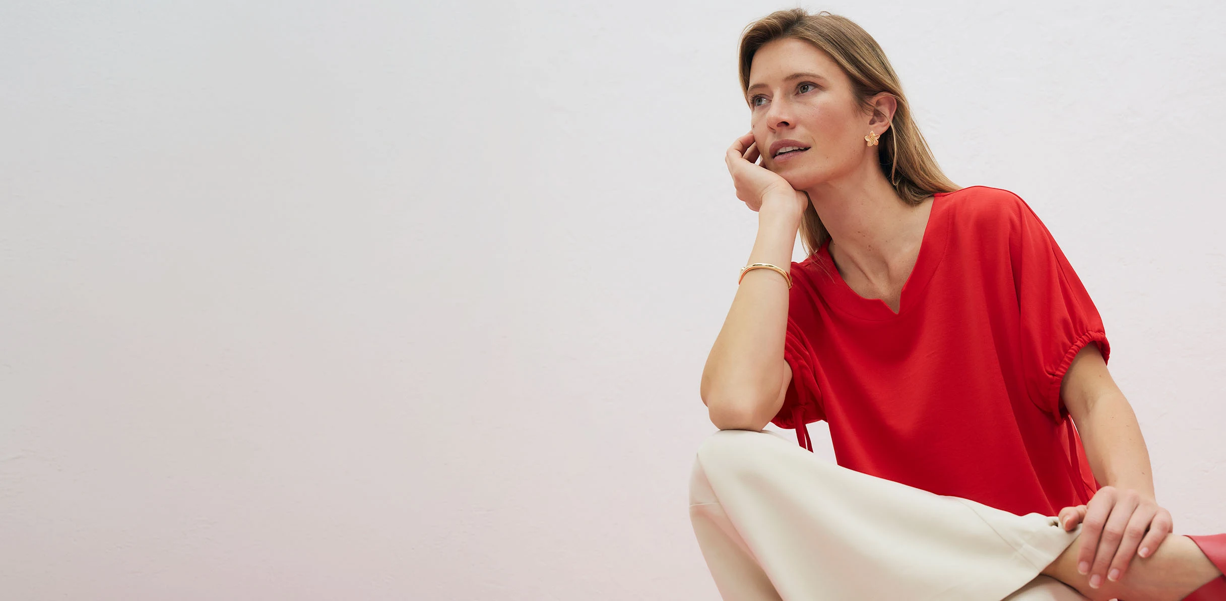 Elegant rood T-shirt met V-hals, gecombineerd met lichte broek.