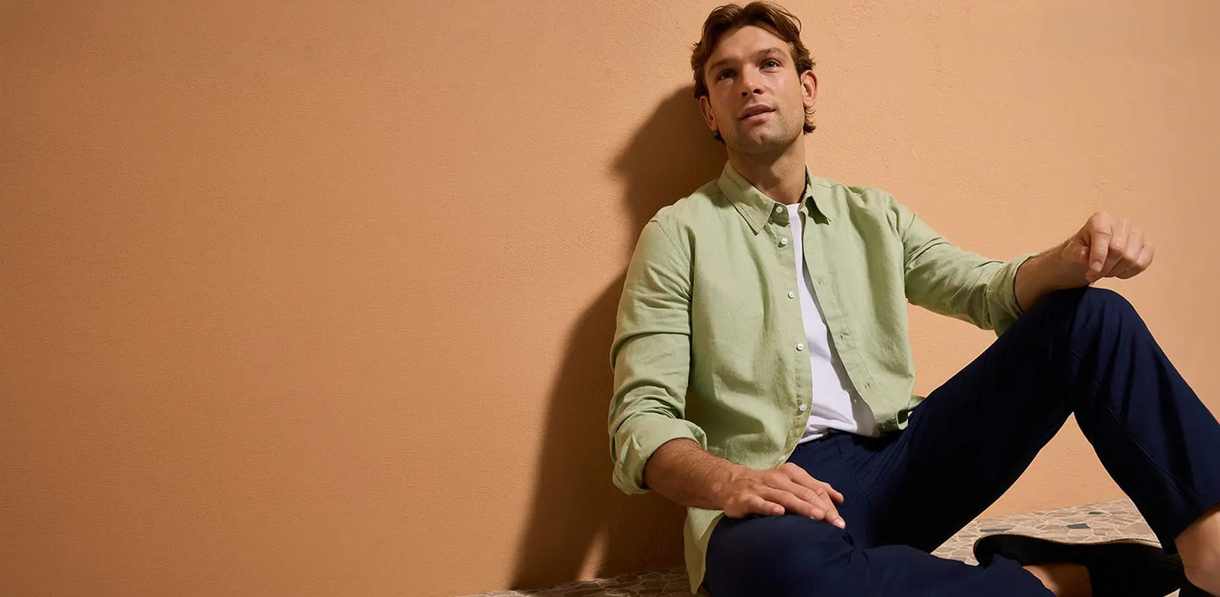 Pastelgroen overhemd, donkerblauwe broek en casual schoenen.