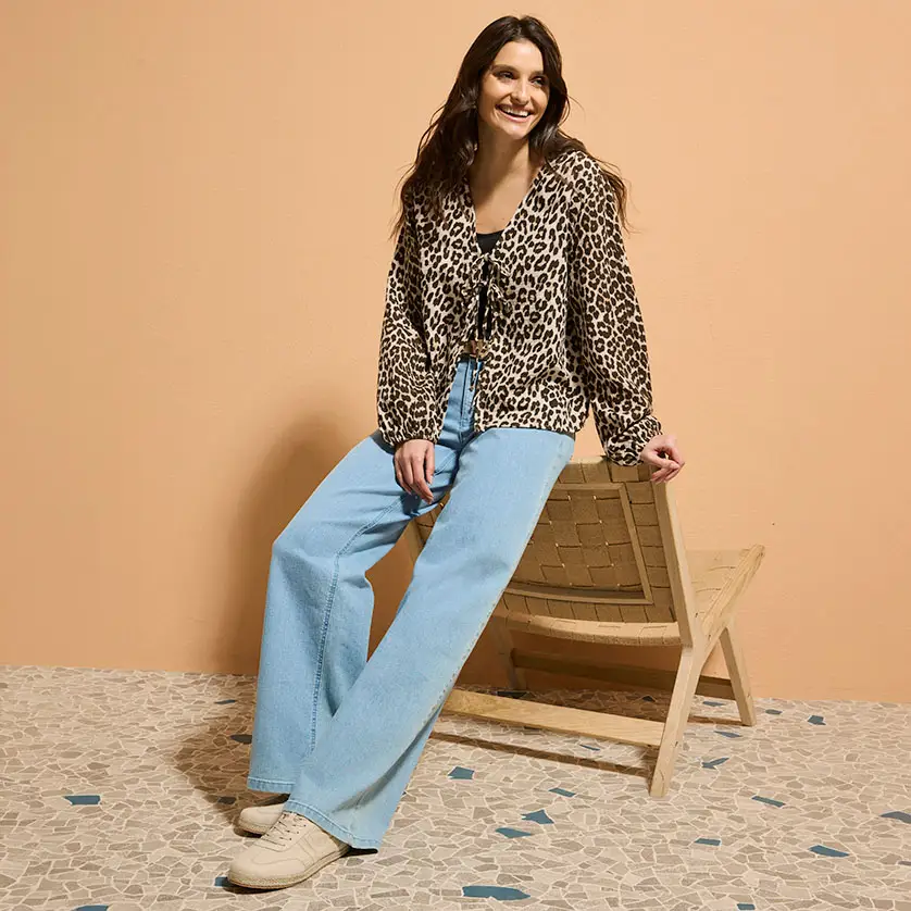 Blouse met luipaardprint gecombineerd met lichtblauwe bootcut jeans.