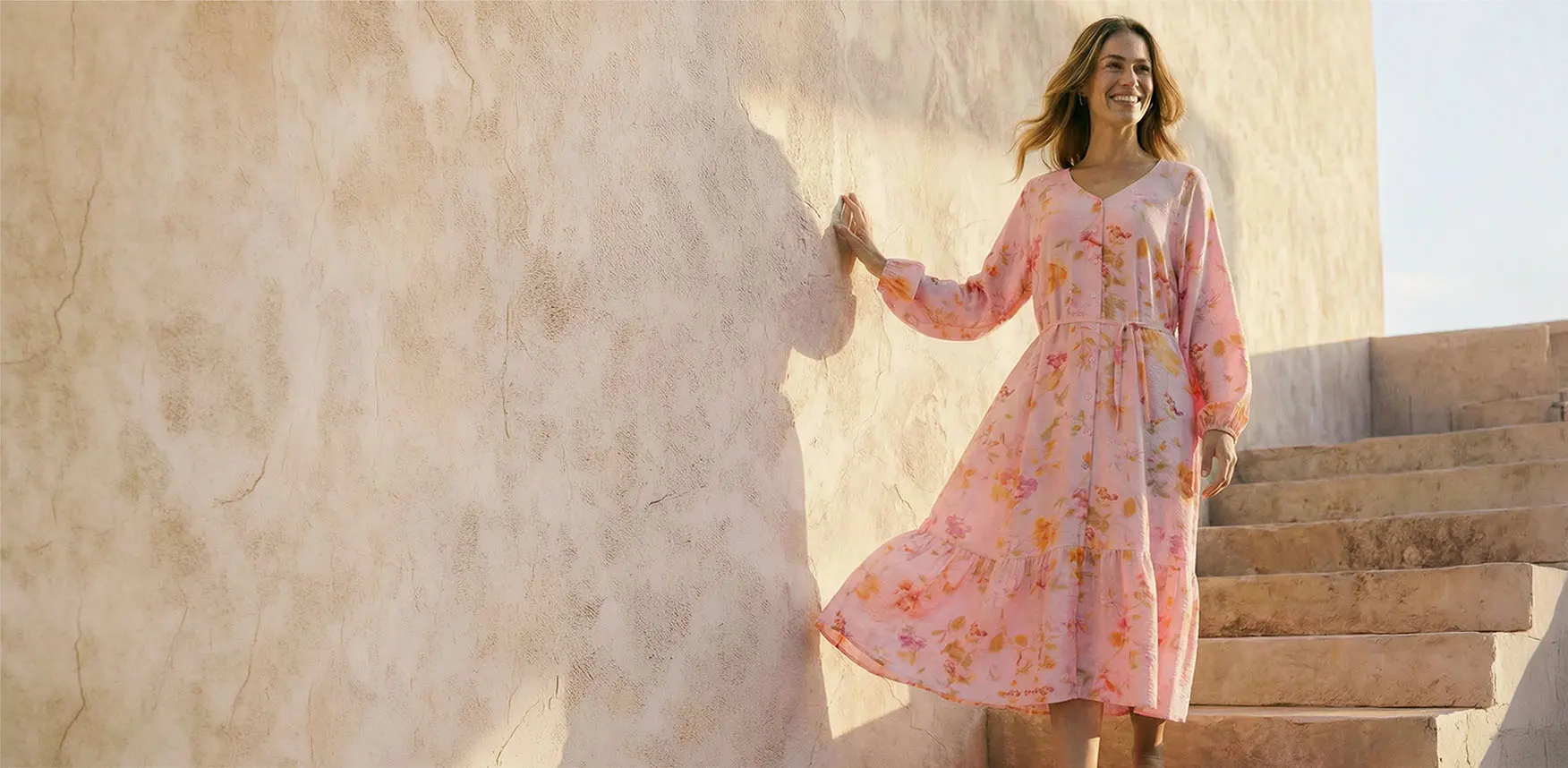 Zachtroze jurk met bloemenprint.