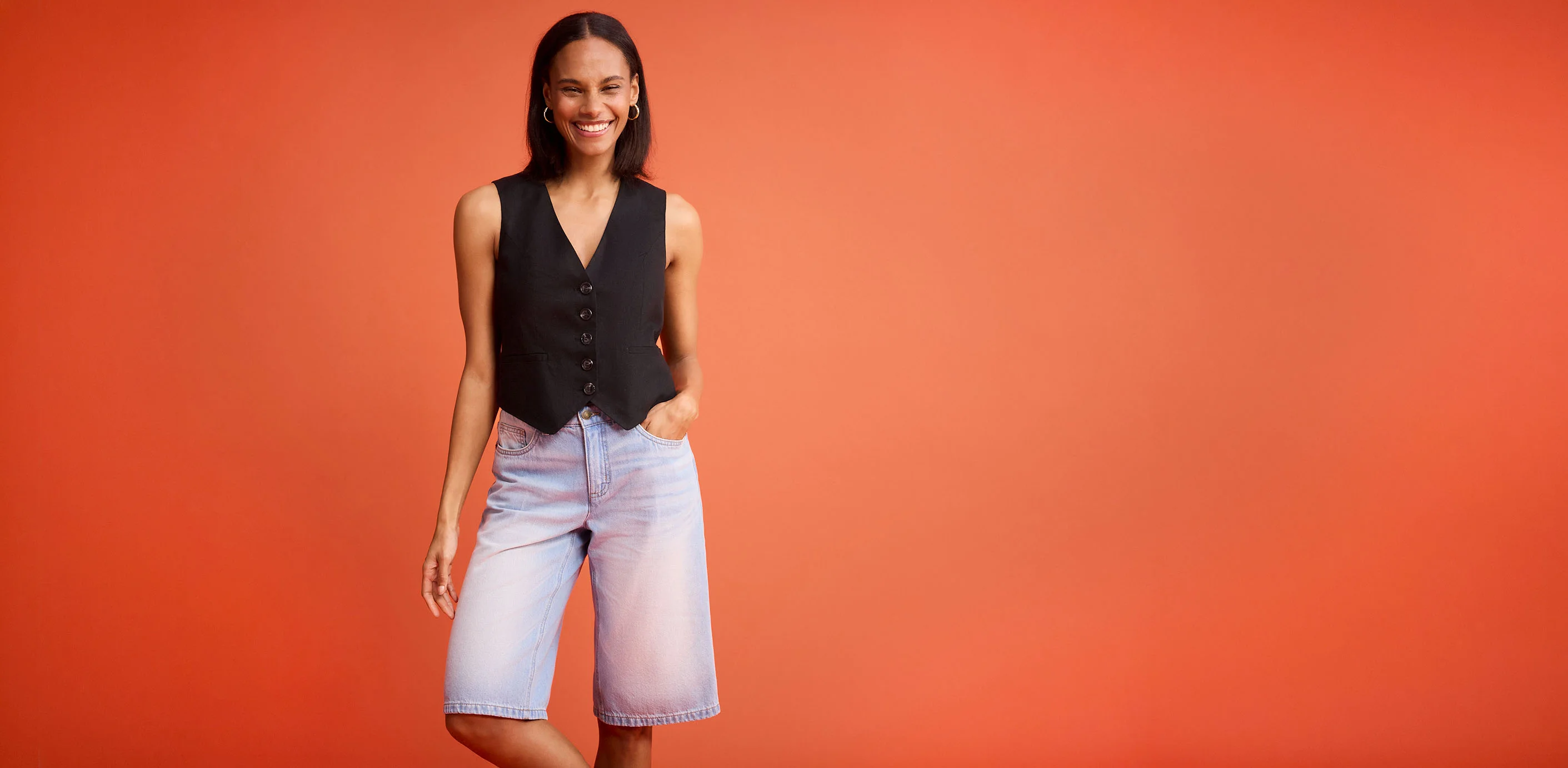 Zwart gilet met knopen gecombineerd met lichblauwe jeansshort.