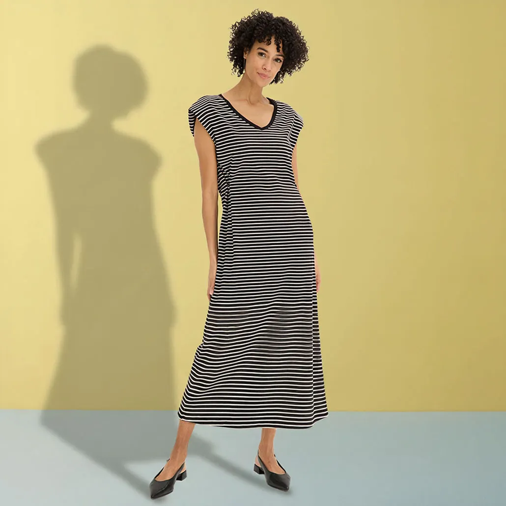 Elegante zwart-wit gestreepte maxi jurk met V-hals en zwarte ballerina's.