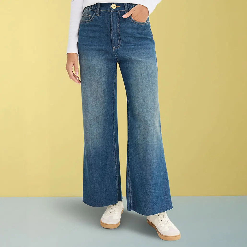 Wijde jeans met wit shirt en lichte sneakers.