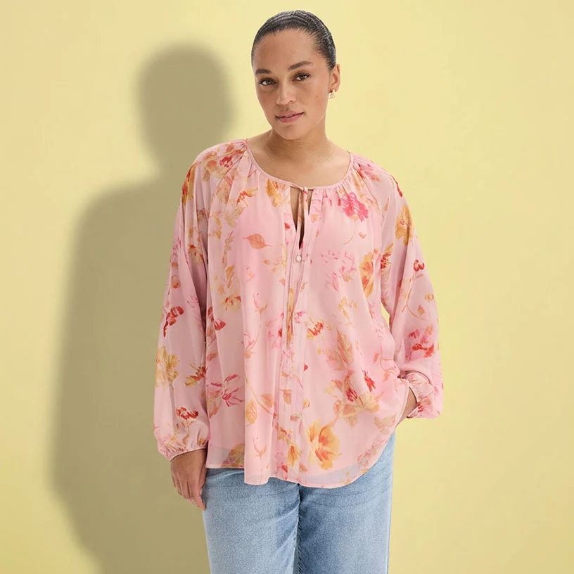 Roze blouse met bloemenprint en casual jeans.
