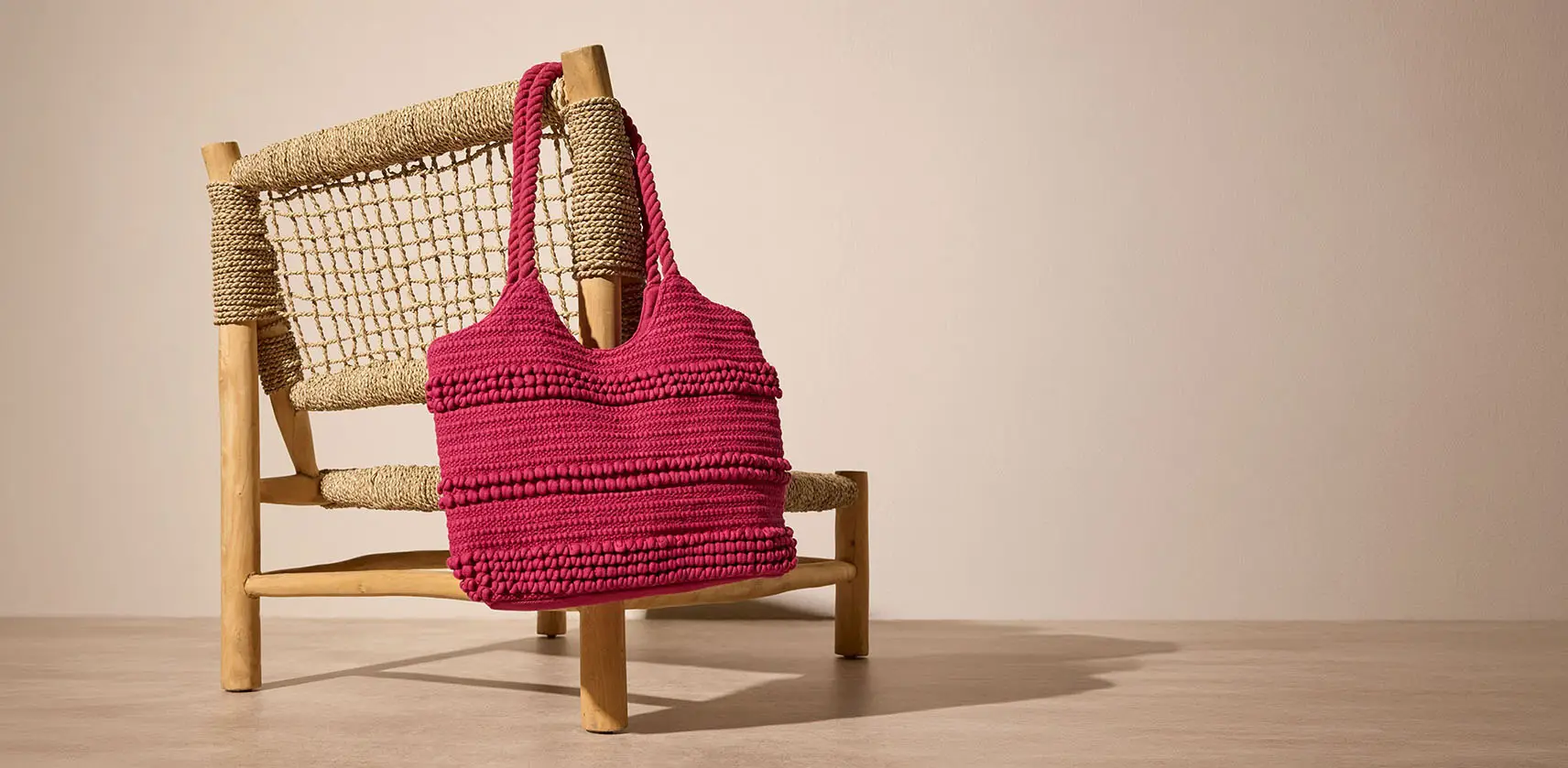 Roze gehaakte tas met oppervlak met structuur.