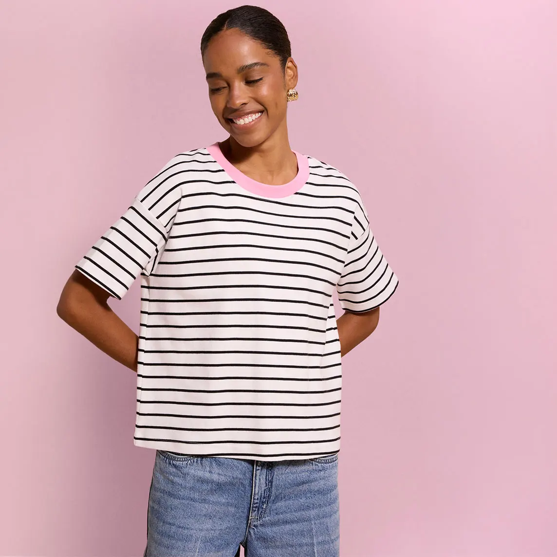 Casual gestreept T-shirt met roze kraag en blauwe jeans.