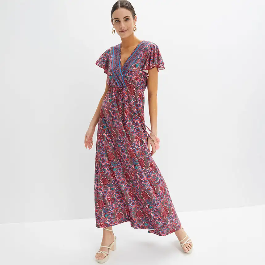 Kleurrijke maxi jurk met paisley dessin, V-hals en korte mouwen gecombineerd met sandalen.