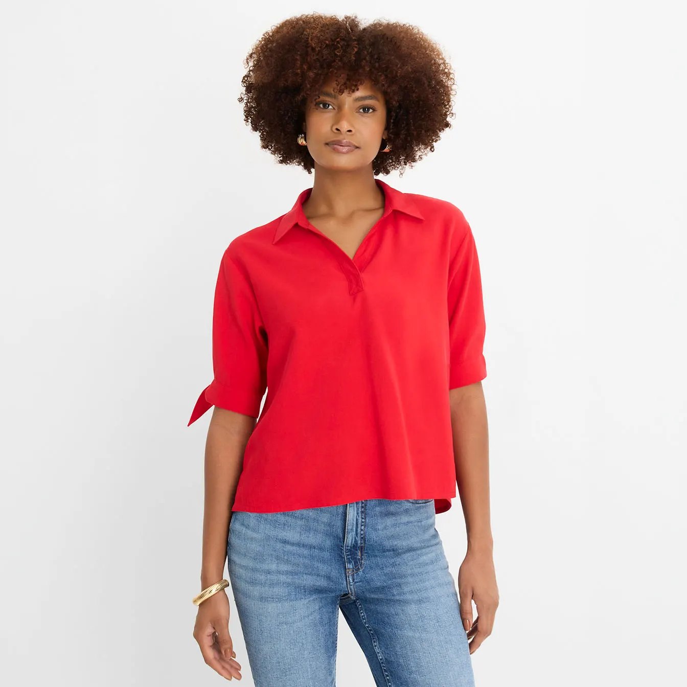 Stijlvolle combinatie: geruite blouse, donkere culotte, elegante sandalen en een tas om je look af te maken.