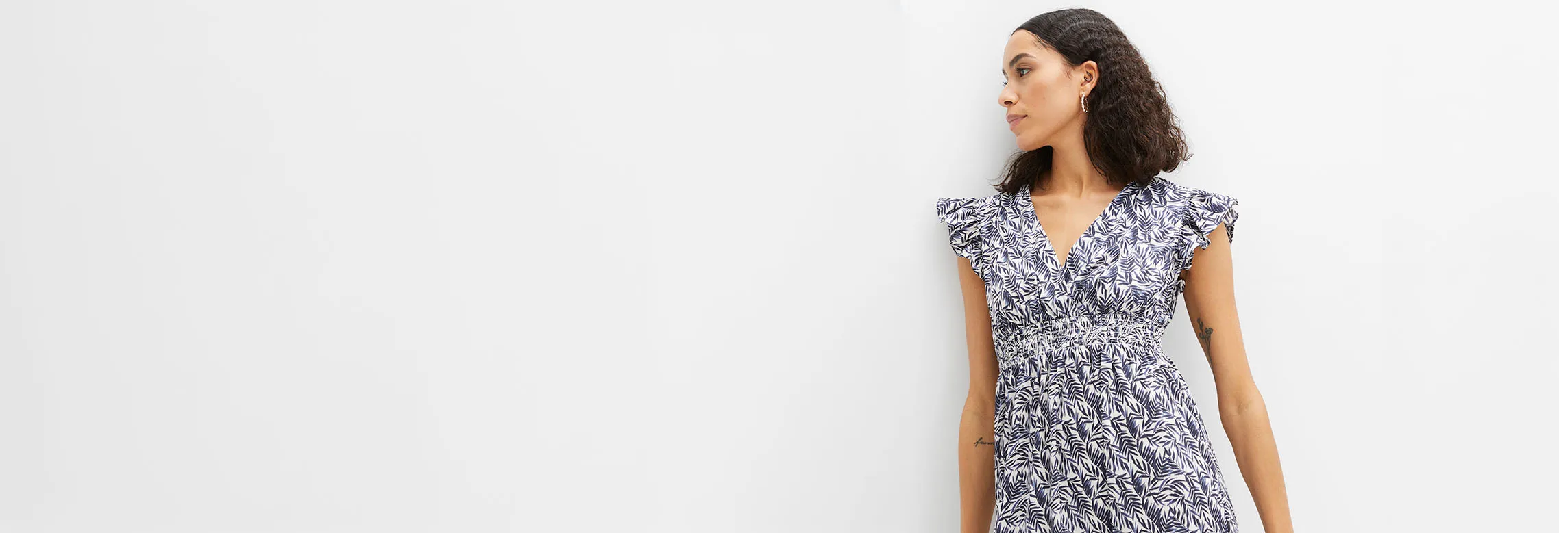 Elegante zomerjurk met blauwe bladerprint, V-hals en plooitjes in de taille.
