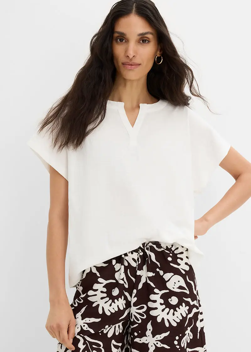 Luchtige witte blouse met V-hals en gedessineerde broek in bruin-wit.