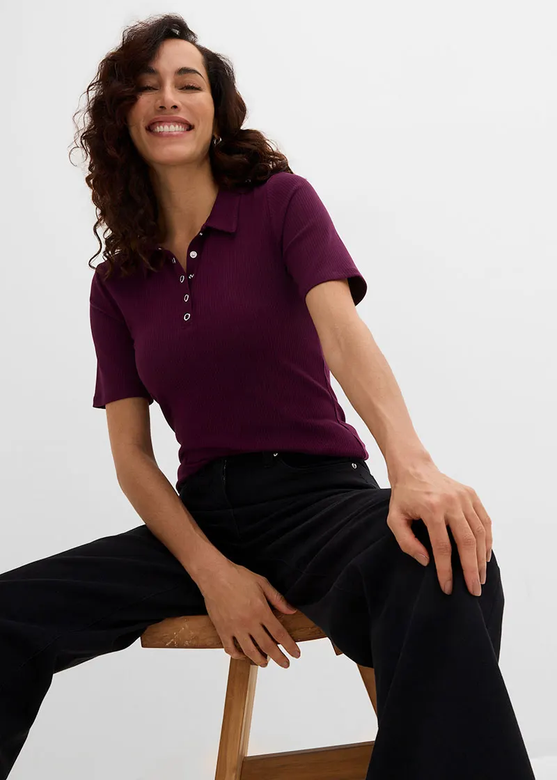 Bordeauxrood poloshirt met knoopjes en wijde zwarte broek.