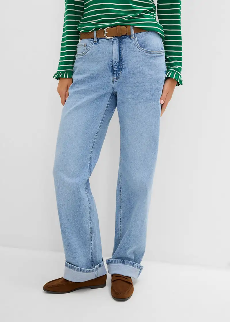 Trendy outfit: gestreept shirt, wijde lichtblauwe jeans, bruine riem en bruine suède loafers.