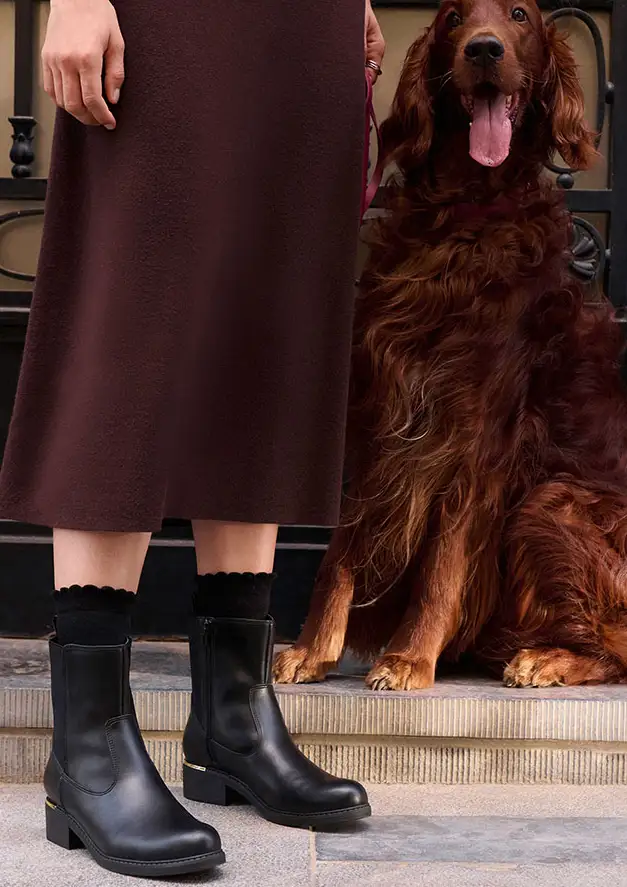 Bruine jurk, zwarte sokken en elegante zwarte boots met goudkleurige hak.