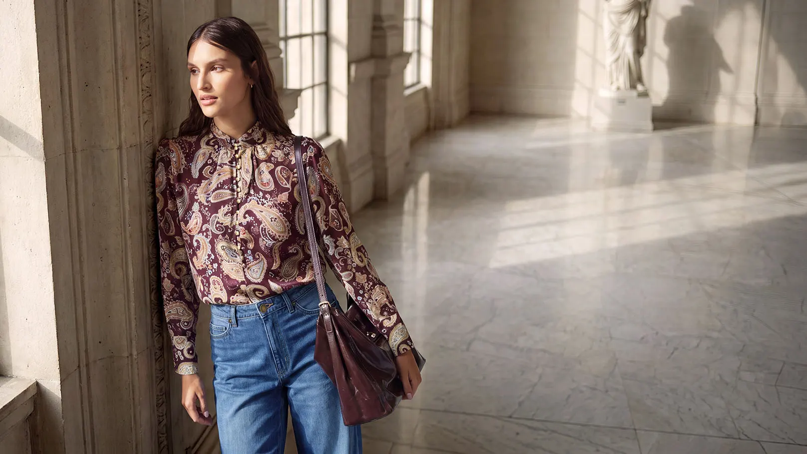 Trendy look: paisley blouse, wijde jeans, elegante schoenen en bijpassende handtas.